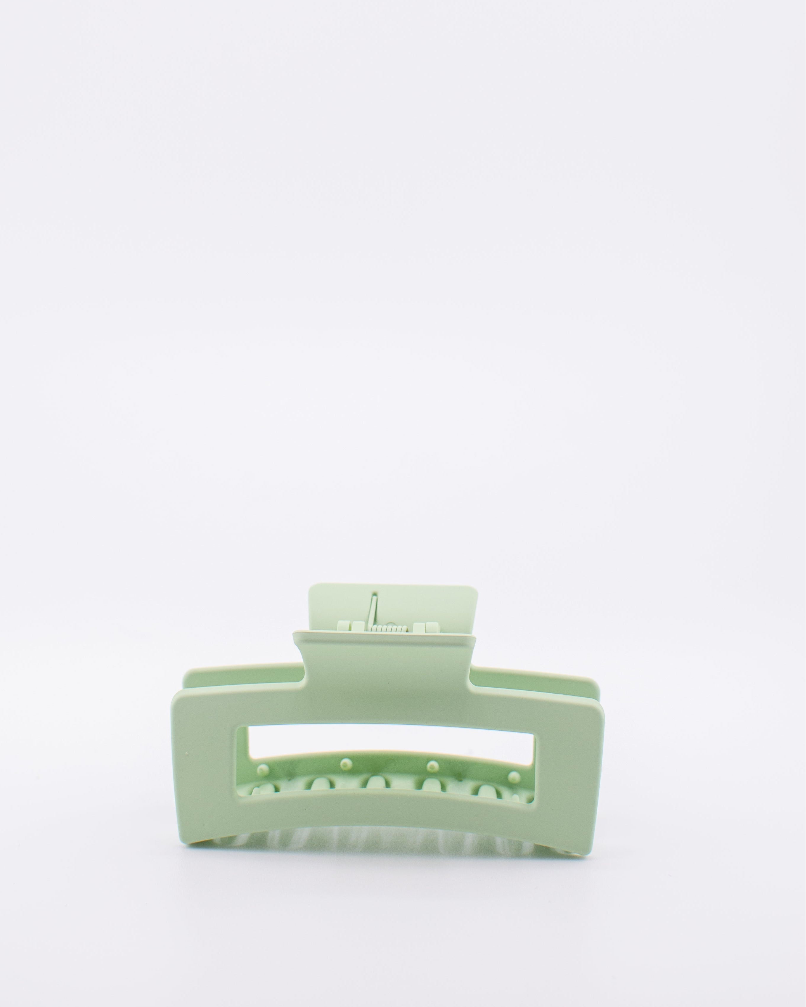 Light green hair clip on a white background