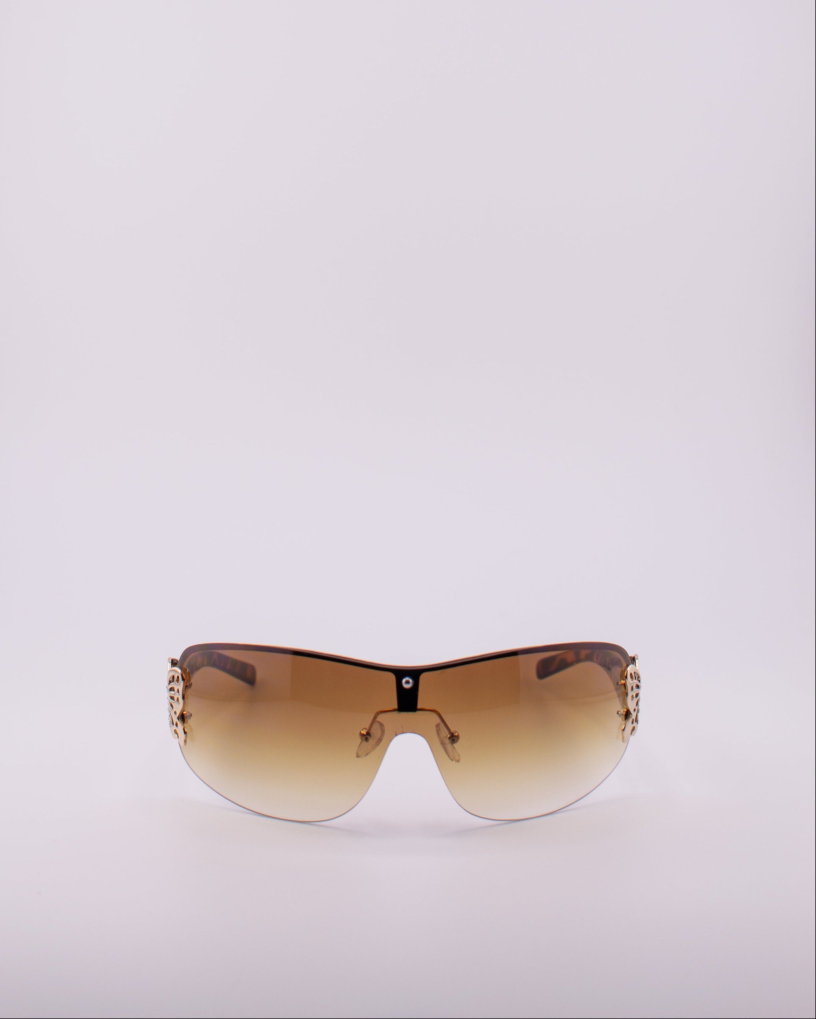 Sunglasses with a gradient brown lens on a light gray background