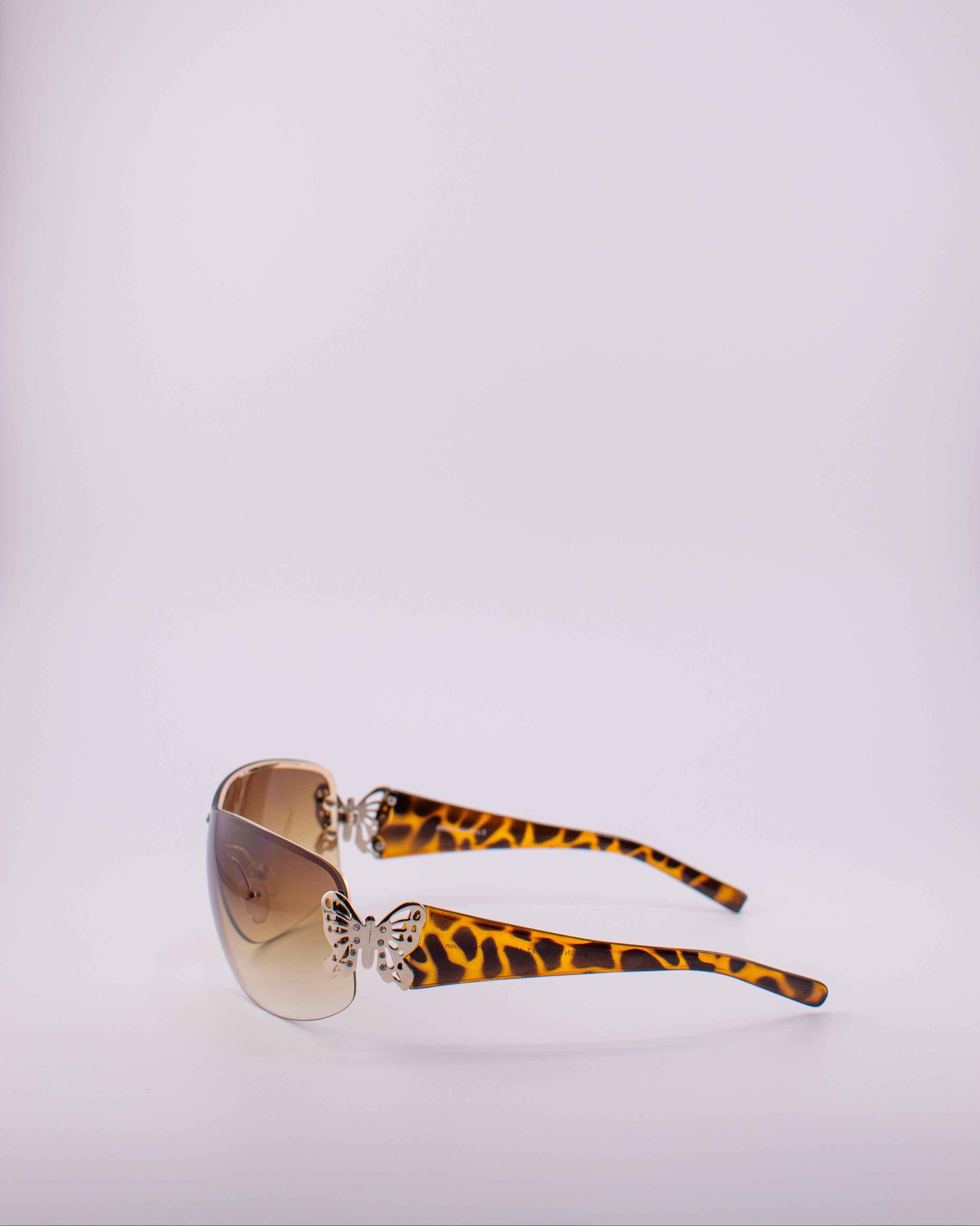Sunglasses with a gradient brown lens on a light gray background